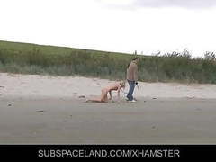 Slim blonde slave leashed and whipped on the beach tubes