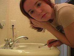 Redhead in tee shirt does her makeup videos