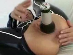 Chick in latex puts a beer bottle in her ass