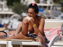 Topless big tits girl has lunch on the beach